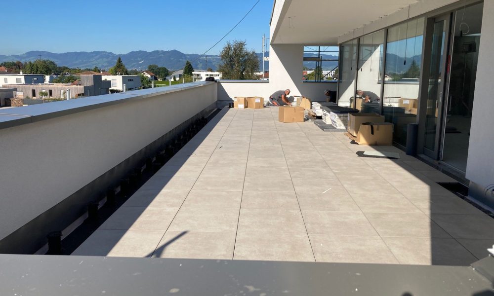 Baustelle, Arbeiter verlegt Platten auf Terrasse