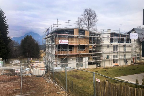 Baustelle Forty in Igls, Neubaugebäude in Gerüst, Arbeiter bringen Holzfassade an