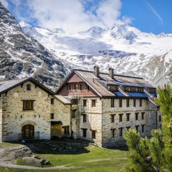 Zwei große Hütten mit alten Mauern in den Alpen