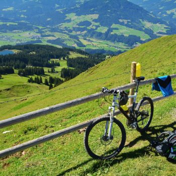 Fahrrad lehnt an Zaun auf der hohen Salve im Hintergrund Blick über das Tal