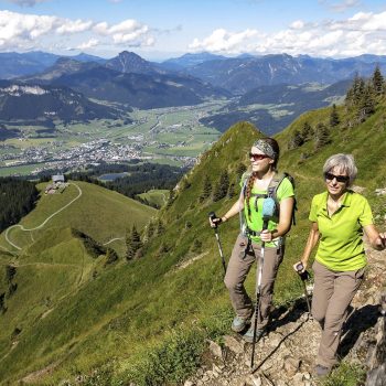 Zwei Frauen beim Wandern in Kitzbüheler Bergwelt, im Hintergrund Blick über das Tal